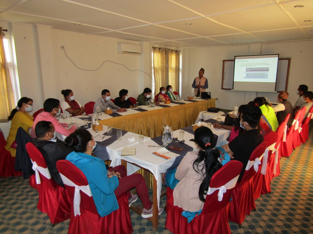 Picture of a Group of people around a table in Nepal attending an orientation and Capacity Building meeting for Right Holders on SDG and Social Accountability tools