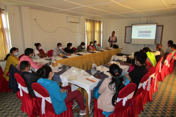 Picture of a Group of people around a table in Nepal attending an orientation and Capacity Building meeting for Right Holders on SDG and Social Accountability tools